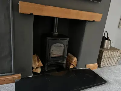 a wood stove in a room with a wall at The Cottage in Carlisle