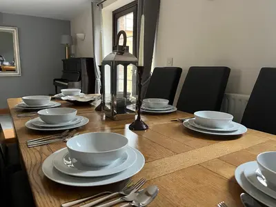 a wooden table with plates and silverware on it at The Cottage in Carlisle