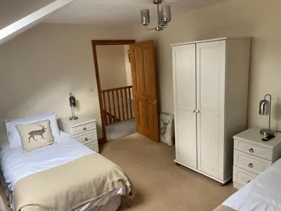 a bedroom with two twin beds and a staircase at The Cottage in Carlisle