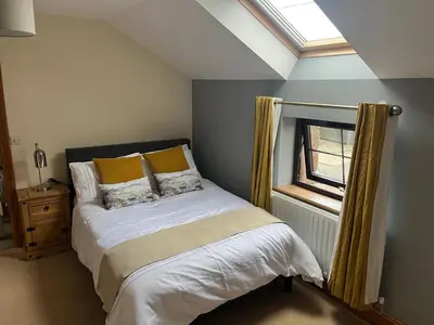 a bed in a room with a window and a bed sidx sidx sidx at The Cottage in Carlisle
