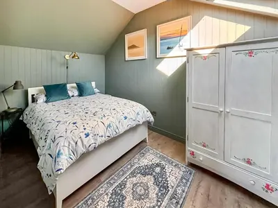 a small bedroom with a bed and a window at Aird Cottage in Dunure