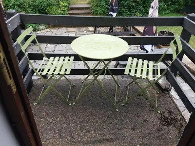 a green table and two chairs on a balcony at NEWFIELD INN in Broughton in Furness