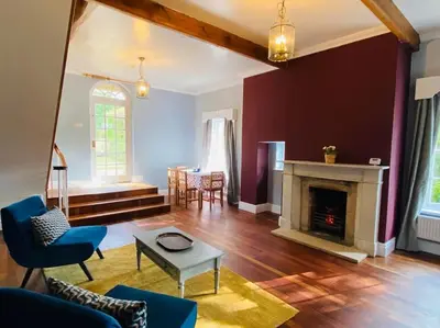 a living room with a fireplace and a table at Unique Country Estate nr Mountains & Beach in Silloth
