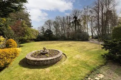 a garden with a fountain in the middle of a lawn at Unique Country Estate nr Mountains & Beach in Silloth