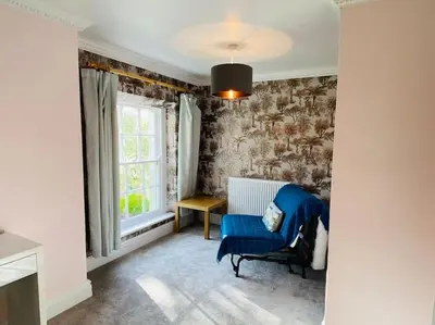 a room with a blue chair and a window at Unique Country Estate nr Mountains & Beach in Silloth