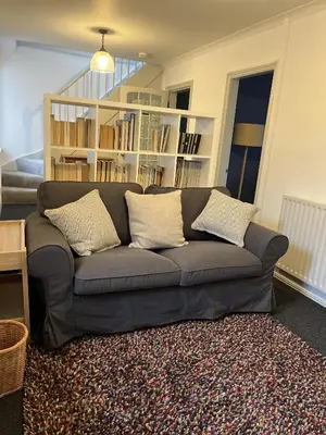 a living room with a couch with pillows on it at Apple Cottage in Wigtown