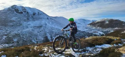a man riding a bike on a snowy mountain at The Chalets in Eskdale