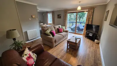 a living room with a couch and a television at The Chalets in Eskdale