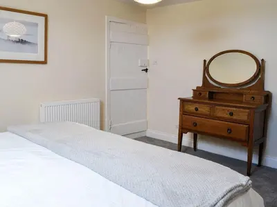 a bedroom with a bed and a mirror on a dresser at Blackloch in Gatehouse of Fleet
