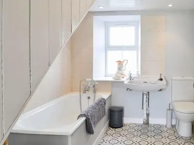 a bathroom with a bath tub and a sink at Blackloch in Gatehouse of Fleet