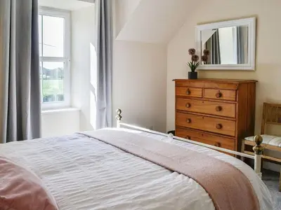 a bedroom with a bed and a dresser and a window at Blackloch in Gatehouse of Fleet