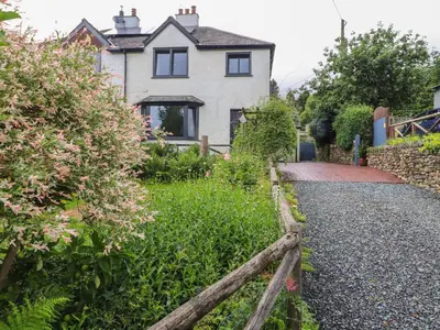 a house with a fence in front of a yard at Beech Croft in Keswick