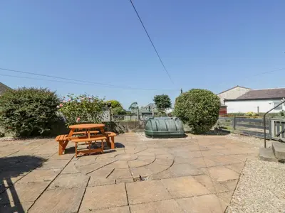 a picnic table and bench on a stone patio at 22 Turnberry Road in Girvan
