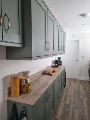 a kitchen with gray cabinets and a wooden counter top at Home from home in Maryport in Maryport