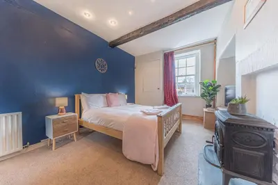 a bedroom with a bed and a blue wall at Abbey Farm House in St Bees