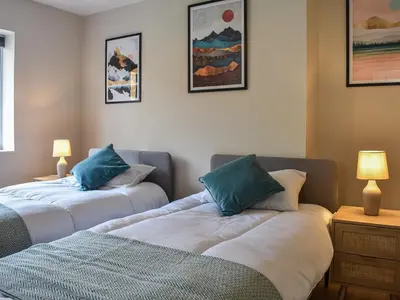 a room with two beds with blue pillows at Tynedale in Keswick