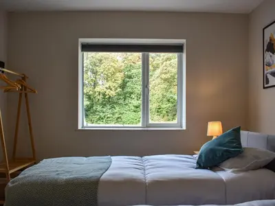a bedroom with a bed and a large window at Tynedale in Keswick