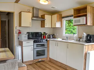 a kitchen with white cabinets and a stove top oven at The Beachcomber in Palnackie
