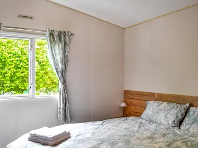 a bedroom with a bed and a window at The Beachcomber in Palnackie