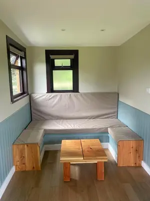 a room with a bed and a table in it at Craigengillan Mini Lodge in Dalmellington
