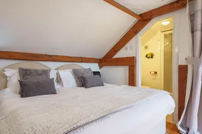 a bedroom with a large white bed in a room at Thomas Carlyle Cottage in Thornhill