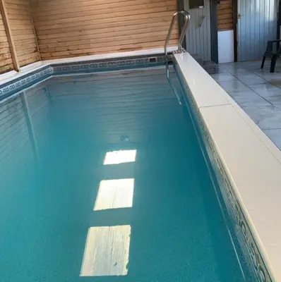 a swimming pool with blue water in a building at Thomas Carlyle Cottage in Thornhill