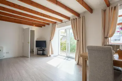 a living room with a table and a television at Morton Cottage in Thornhill