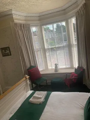 a bedroom with two chairs and a bed and a window at Seamore House in Moffat
