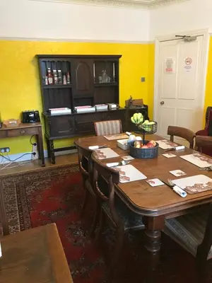 a dining room with a table and a piano at Seamore House in Moffat