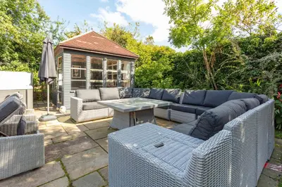 a patio with a blue couch and a table at Burnock Lodge with Hot Tub in Ayr