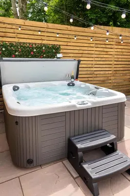 a jacuzzi tub with a bench in a backyard at Cottage - Sleeps 4 hot tub & pet friendly in Carlisle