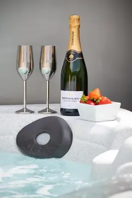 a bottle of wine and two wine glasses on a table at Cottage - Sleeps 4 hot tub & pet friendly in Carlisle