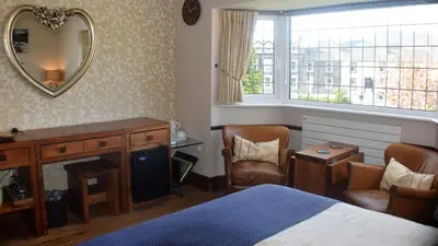 a bedroom with a bed and a mirror and a desk at Riverside Escape in Keswick