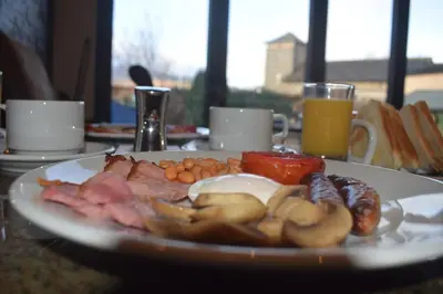 a plate of food on a table with eggs meats and vegetables at Riverside Escape in Keswick