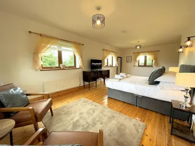 a bedroom with a bed and a desk in it at Spectacular 7BR House Hot Tub and Gardens in Gretna - Pass the Keys in Gretna Green