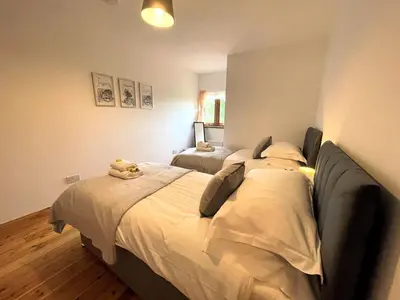 a bedroom with a large bed with a stuffed animal on it at Spectacular 7BR House Hot Tub and Gardens in Gretna - Pass the Keys in Gretna Green