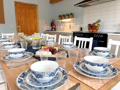 a table with bowls and plates on it in a kitchen at Spectacular 7BR House Hot Tub and Gardens in Gretna - Pass the Keys in Gretna Green