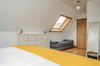 a bedroom with a bed and a dresser and a window at Southcliff House in Portpatrick