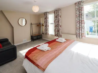 a bedroom with a large bed with two towels on it at Bay Tree Cottage in Keswick