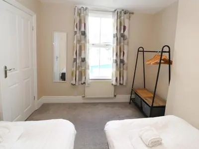 a bedroom with two beds and a window at Bay Tree Cottage in Keswick