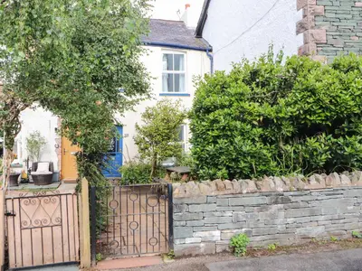 a house with a gate and a stone wall at Bay Tree Cottage in Keswick