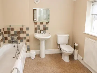 a bathroom with a toilet and a sink and a tub at Bay Tree Cottage in Keswick