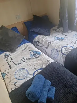 two beds in a room with blue towels on them at Serenity in Monreith