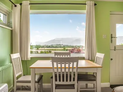 a dining room with a table and chairs and a large window at High Spy in Bassenthwaite