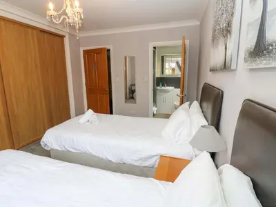 a hotel room with two beds and a mirror at Fern Lee in Carlisle