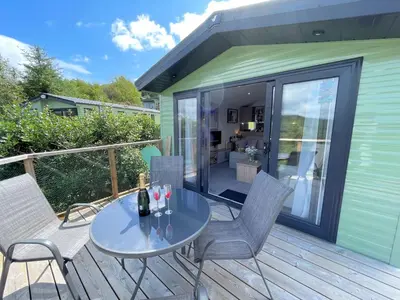 a patio with a table and chairs on a deck at Gorgeous Kippford Home With Outstanding Views - Pass the Keys in Kippford