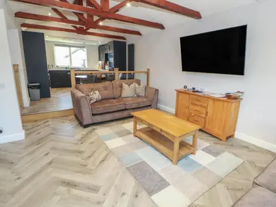 a living room with a couch and a flat screen tv at Mallard Cottage in Penrith