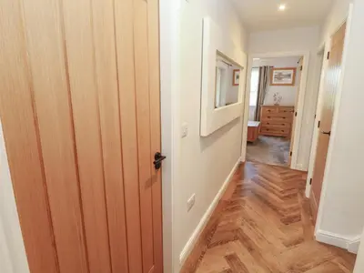 a hallway with a door leading into a room at Mallard Cottage in Penrith