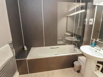 a bathroom with a tub and a sink at Mallard Cottage in Penrith