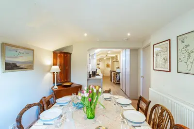 a dining room with a table with flowers on it at Kenmure Kennels in New Galloway
